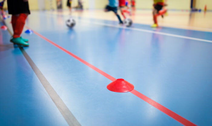 group of kids training indoor soccer futsal. children physical education class. gym class for youth. futsal training picture with blurred background