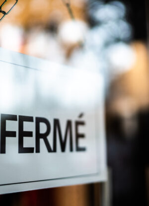 closed sign (fermé) seen through glass by at store