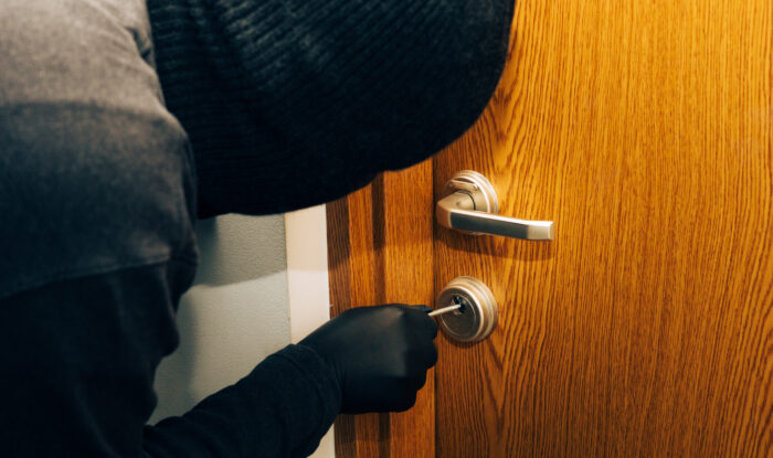 a man in a black balaclava and gloves breaks into the apartment