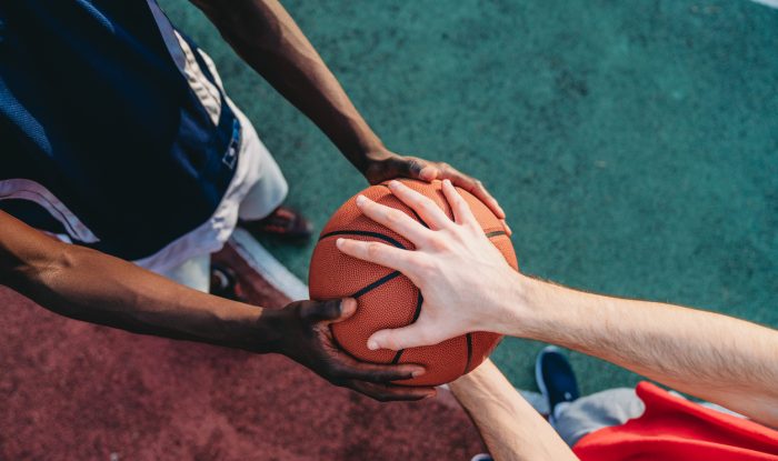 two friends are holding a basketball ball at the pick up basketball court