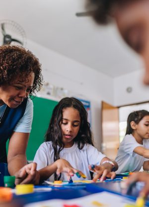 teacher teaching her students on art class at school