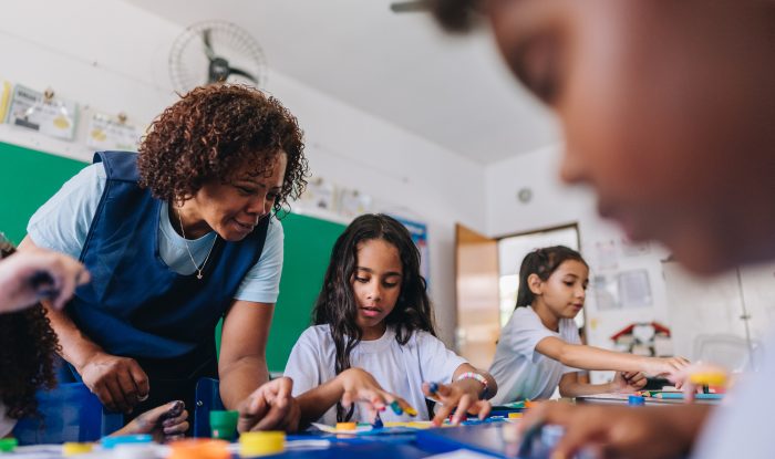 teacher teaching her students on art class at school