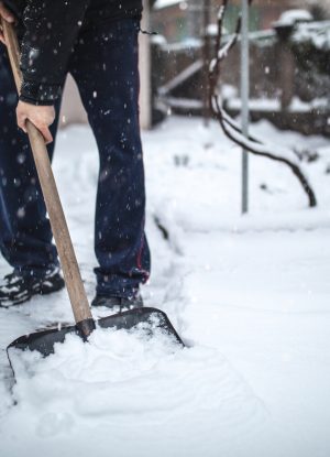 close up of a man clening his driveway after a heavy snowfall