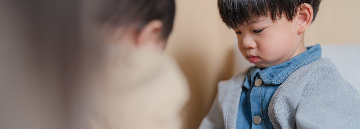 little asian brother looking at his baby sister playing together at home authentic sibling interaction and bonding cute toddler boy watching younger sibling with curiosity family love concept