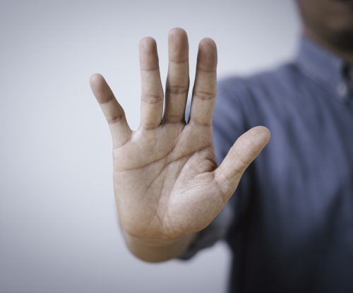 stop gesture with an open hand signaling protection, rejection and personal boundaries. business concept representing safety, prevention, refusal, awareness and human rights with copy space.